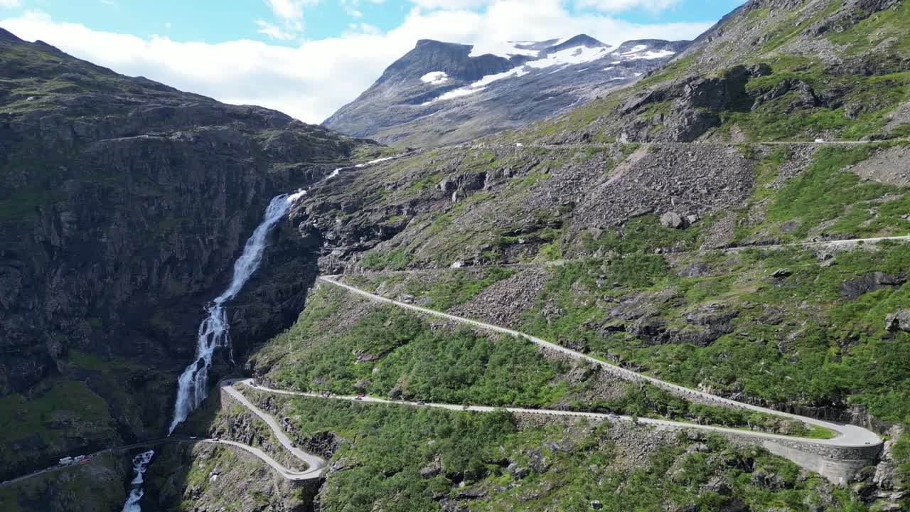 trollstigen carretera de montaña en noruega - coches conducen ruta turística a lo largo de cascadas escénicas y curvas de horquilla - círculos aéreos