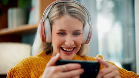 woman playing game on her phone with headphones
