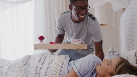 hombre trayendo desayuno a la mujer en la cama para celebrar el cumpleaños o el día de san valentín