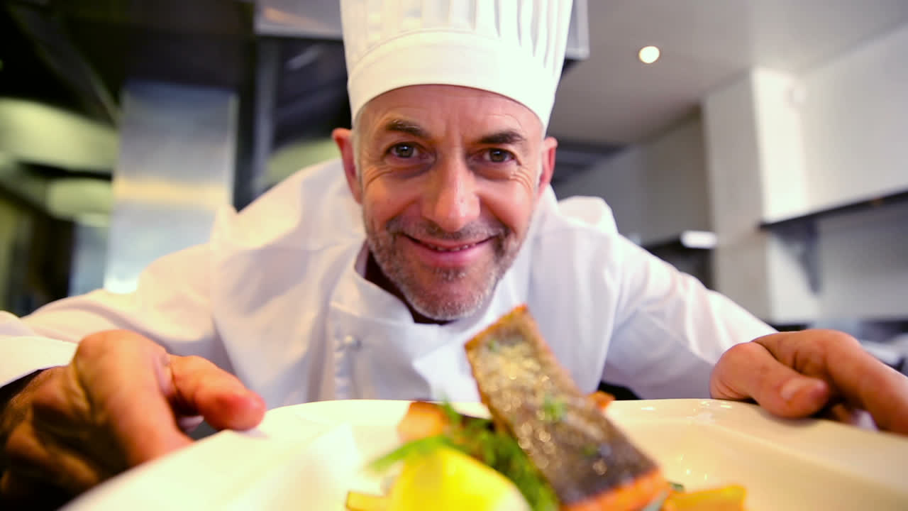 cocinero feliz adornando el plato de salmón