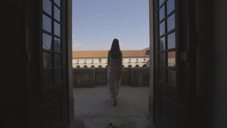Woman in a Dress on a Balcony with a View of a Monastery