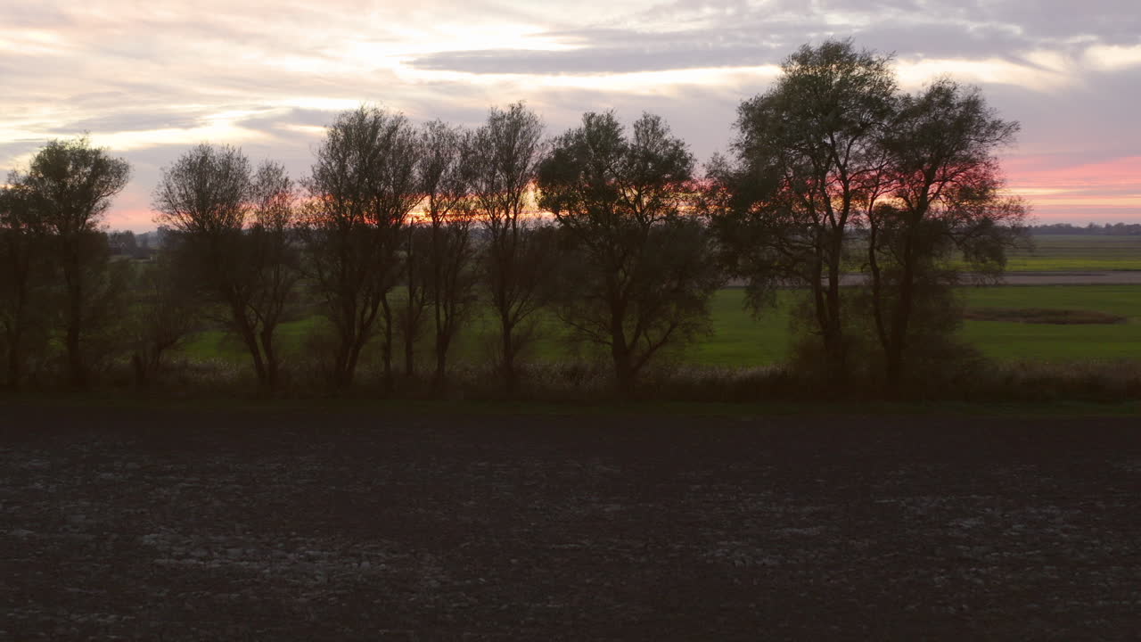 Landlig jordbruksområde under solnedgangen, sørvest i Nederland.