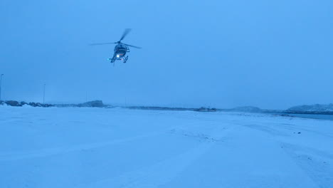 helicopter landing with lights one in the snowy arctic, lofoten, norway, static shot