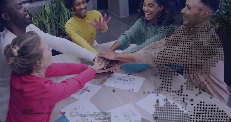 Woman in yellow reaching, team stacking hands over business charts, dotted overlay for team unity