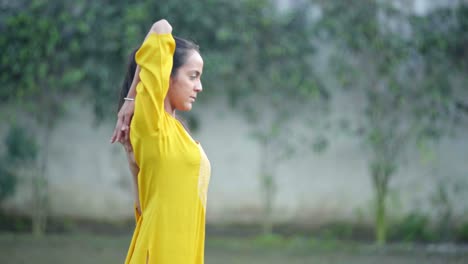 indian girl performing cow face yoga pose in side angle