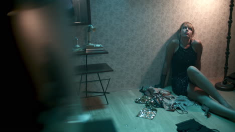 Woman sitting on the floor in a dimly lit room