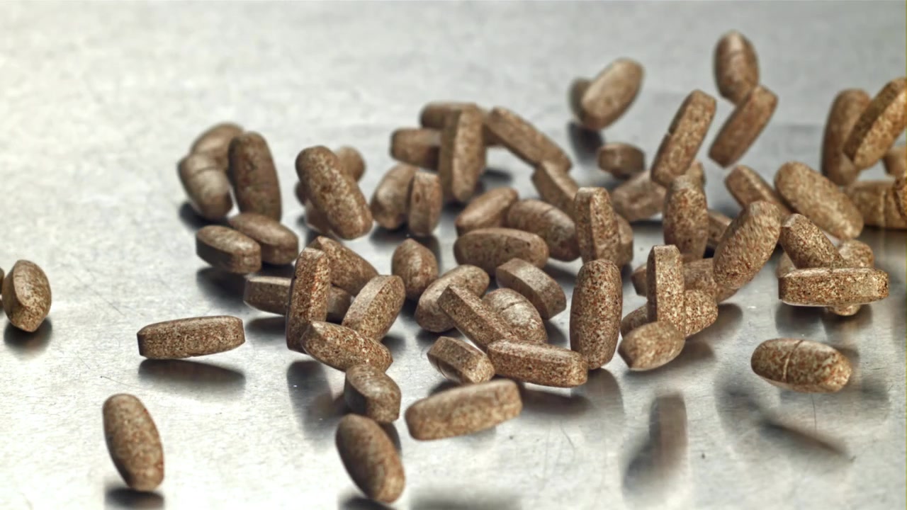 Textured Brown Pills Falling and Scattering on a Metallic Surface