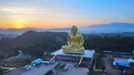 panorámica amplia y lenta de 4k alrededor de la imagen dorada de luang pu thuat, el monje más famoso y respetado de tailandia