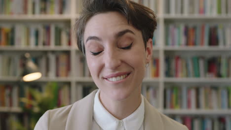 close up portrait of young professional business woman enjoying silly fun making faces spontaneous female wearing stylish suit in library office background