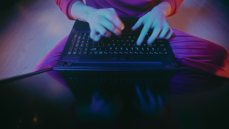 Mand skriver på bærbar computer i et oplyst hjem i juletiden.
