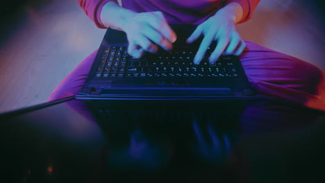 man typing on laptop at illuminated home during christmas