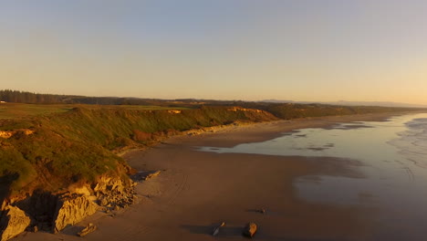 Drone-Descendiendo-Sobre-Whisky-Run,-Una-Playa-Cerca-De-Bandon-En-La-Costa-Sur-De-Oregon-Durante-La-Puesta-De-Sol