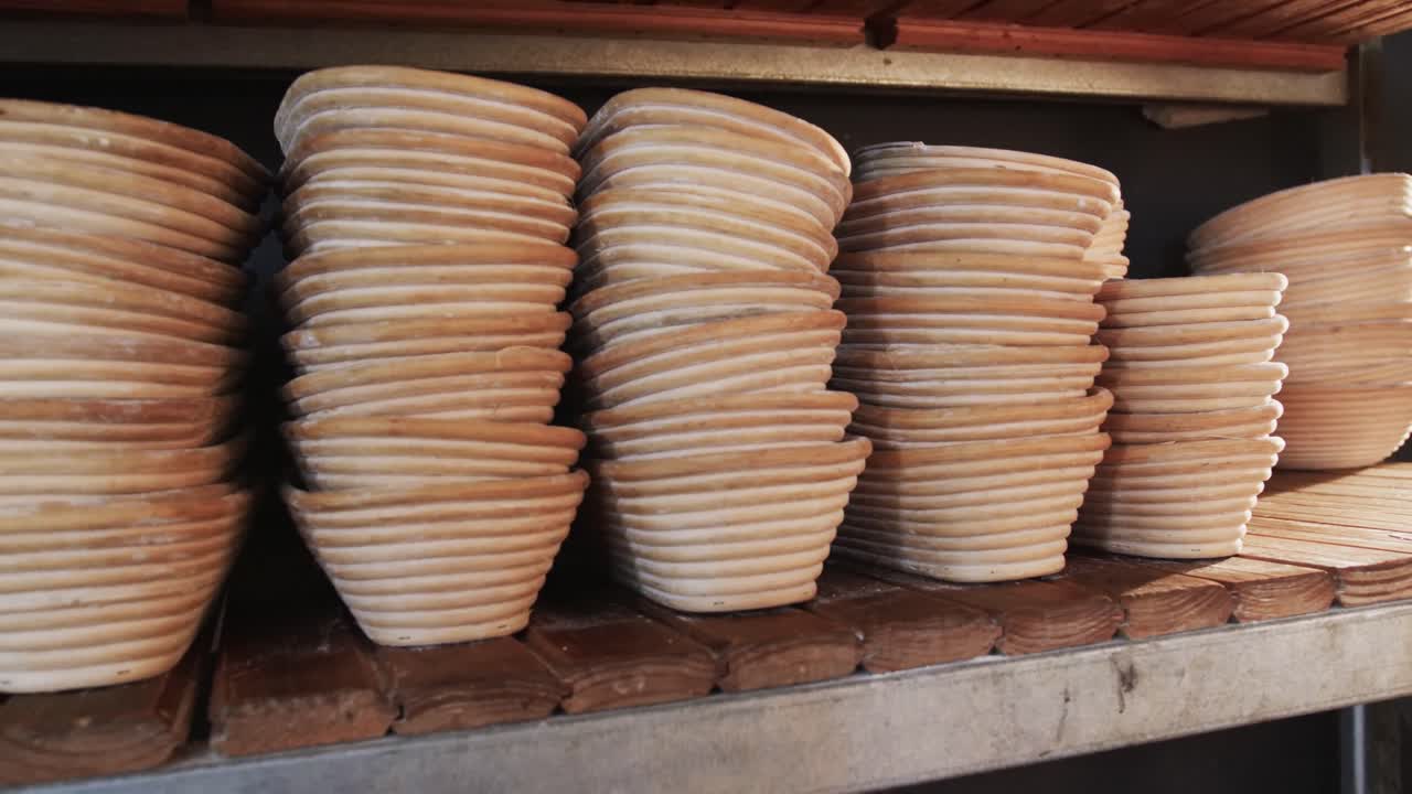 Close up of piles of pottery bowls on shelves in bakery kitchen, slow motion