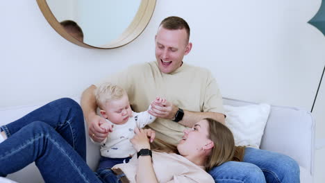 funny cute child having fun with parents. happy family playing together in home.