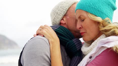 senior man kissing senior woman on cheeks