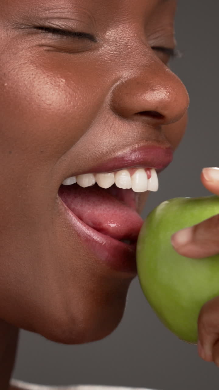 Mulher comendo uma maçã verde