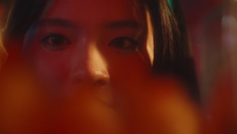 close-up of a woman in a dimly lit space.