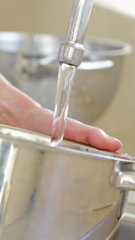 woman filling pot with water from the tap