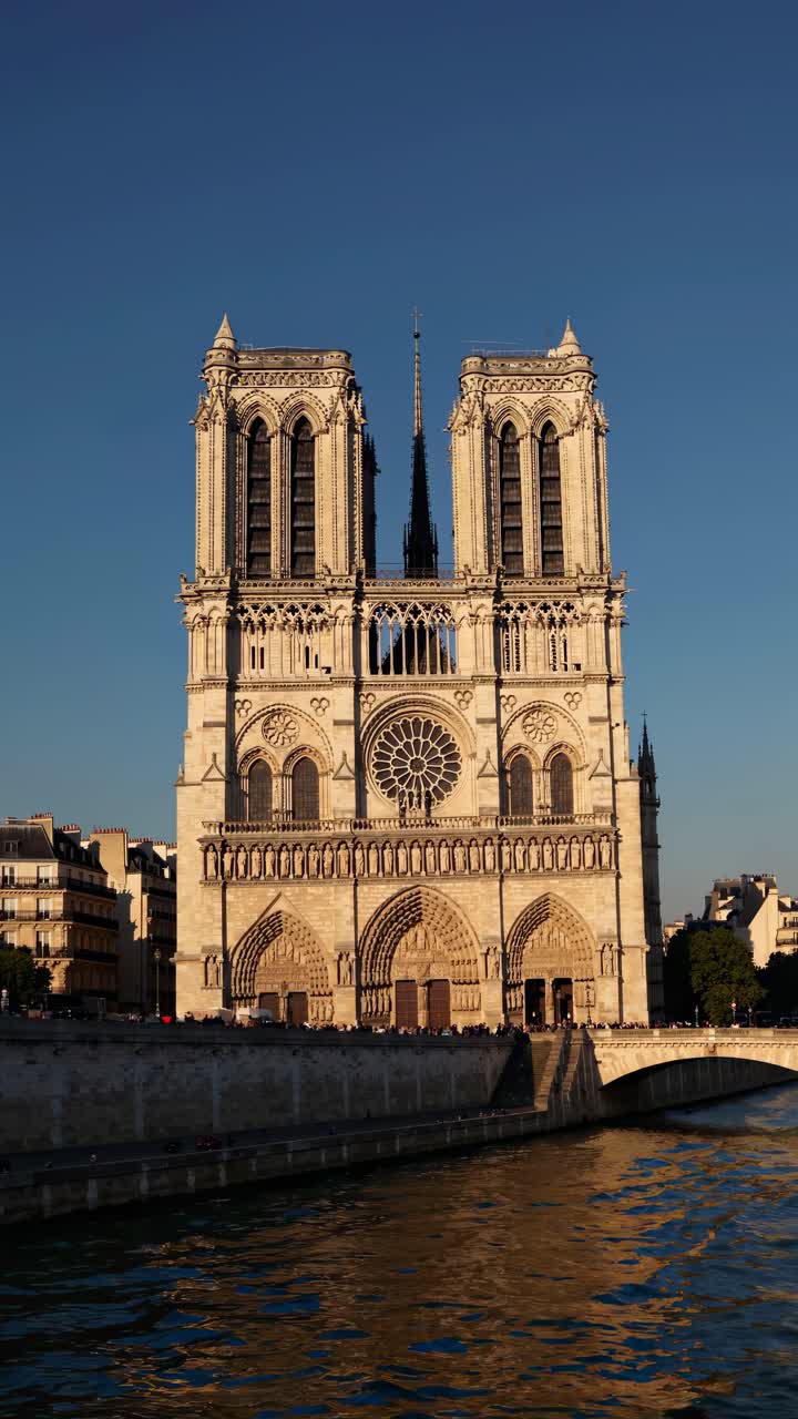 Düşük açıdan çekilmiş bir video, gün batımında Notre-Dame Katedrali'nin ikonik Gotik cephesini yakalıyor