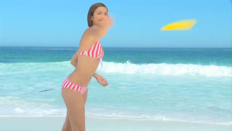 mujer en traje de baño despojado jugando al frisbee