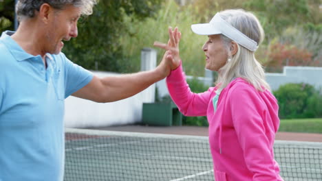 senior couple giving high five in tennis court 4k