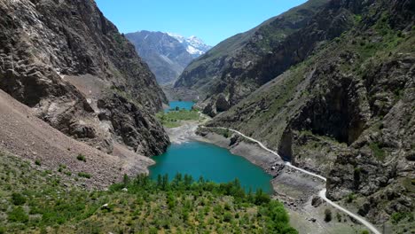 drone flying through mountain valley with lake in pamir mountains