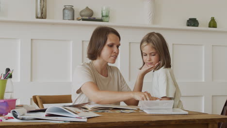 a mother does homework with her daughter and places a metal utensil on her tongue to help her understand how taste buds work