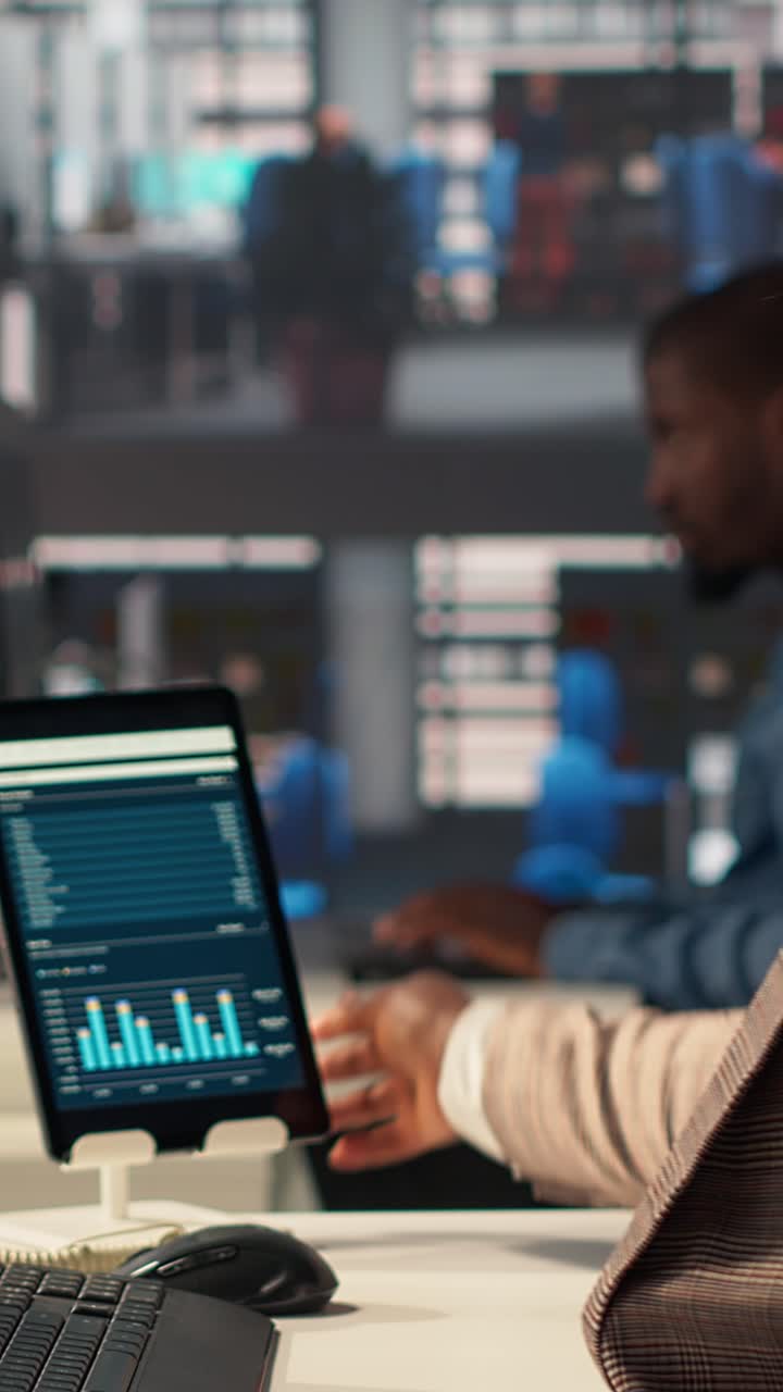 African American Businesswoman Analyzing Data on Tablet and Computer in Office