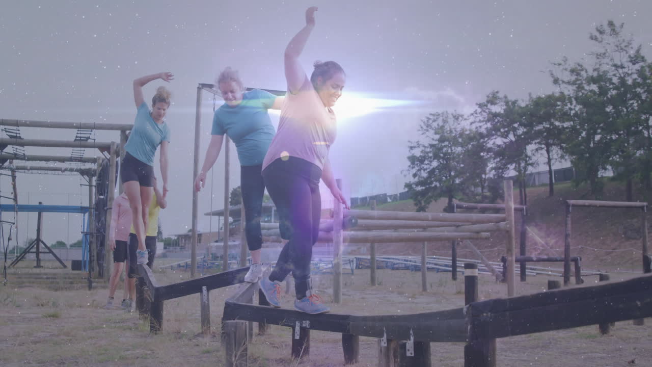 People balancing on outdoor obstacle course with glowing light animation effect