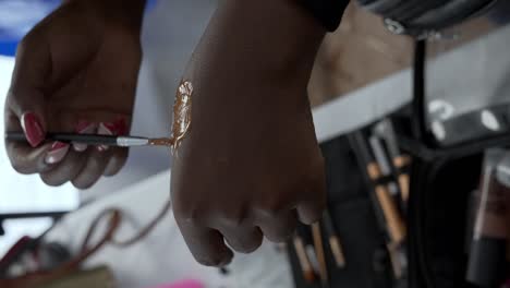 a makeup artist applying makeup to an actor during the filming of a commercial - vertical shot