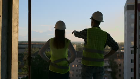 Los-Constructores-Miran-Un-Paisaje-Urbano-En-Una-Vista-Posterior-Del-Fondo-Del-Atardecer.