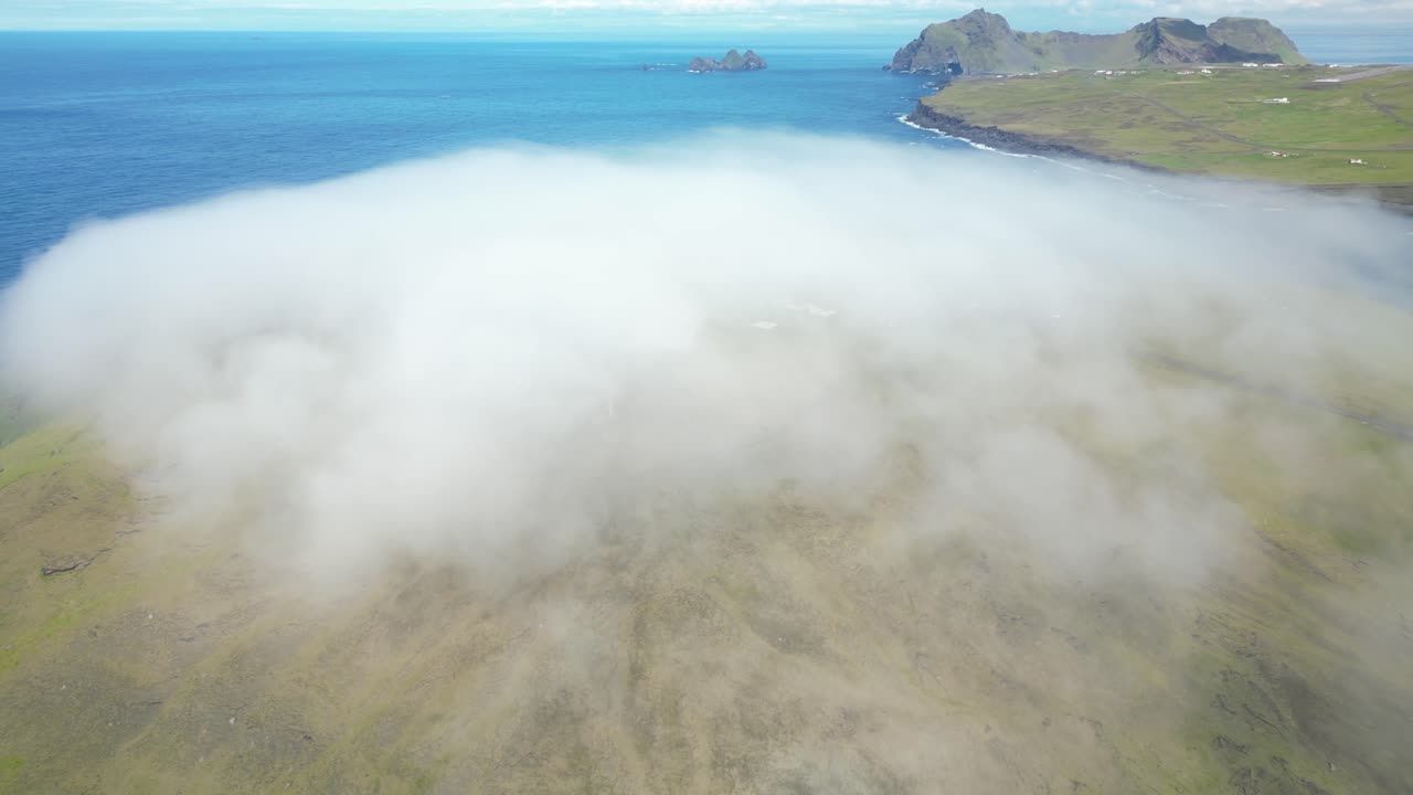 Aerial view of dense mist cover the southern remote Icelandic landmark, touristic Vestmannaeyjar