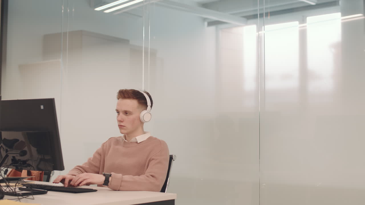 Young IT Student in Headphones Working on Computer