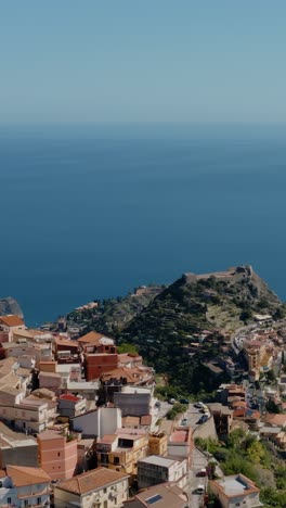 vertical aerial view of charming historic village in sicily. ancient town up in the mountains on the edge of a cliff.