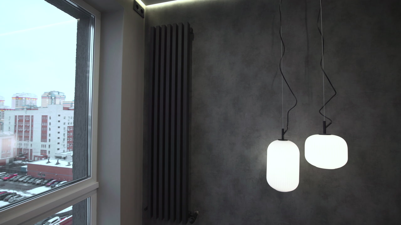 Byudsigt gennem vindue med pendellamper i lejlighedsinteriør, sneklædt bypanorama gennem glas, væg med tekstureret puds. Medie