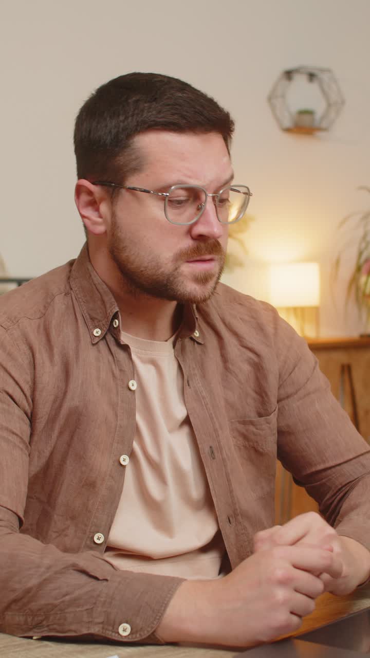 hombre de negocios estresado y molesto con una computadora portátil mirando facturas de deuda bancaria no pagadas sentado en el escritorio de la oficina en casa