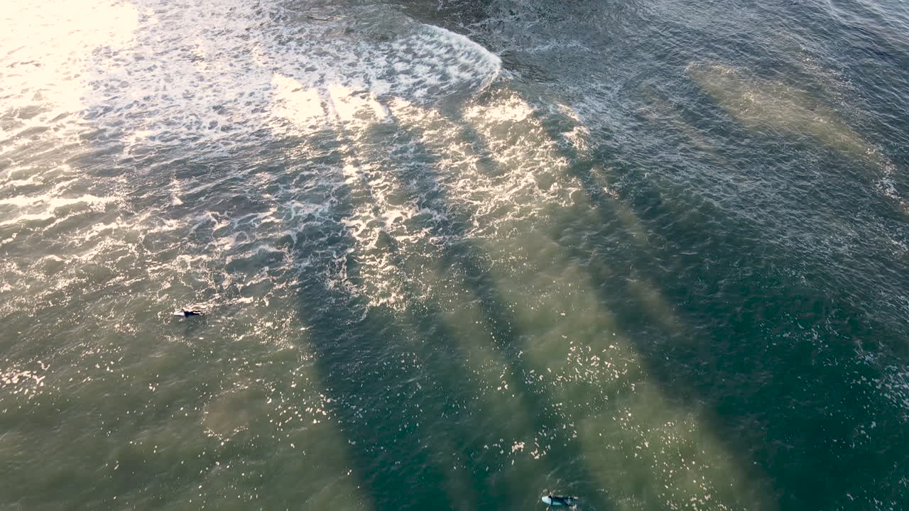 vista aérea de surfistas en la playa de santa cruz california filmada en 4k de alta resolución