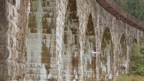 drone volando sobre un viejo puente de piedra