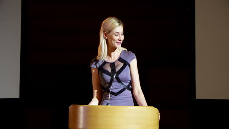 young blonde caucasian businesswoman speaking in business seminar at auditorium 4k