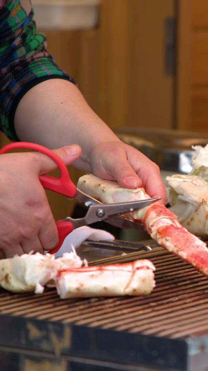 Chef cortando patas de cangrejo real frescas con tijeras de cocina