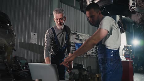 car repair technicians working on a vehicle in a garage