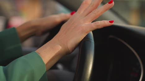 mujer en chaqueta gira el volante moviendo los dedos a la música