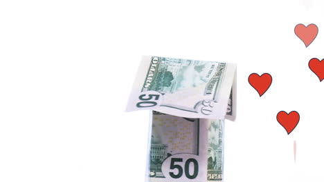animación de iconos de corazón y billetes de dólar que forman una casa sobre un fondo blanco