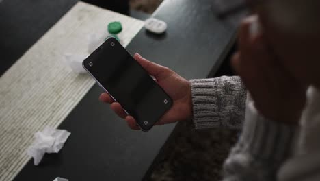 sick african american senior woman having a video call on smartphone with copy space at home