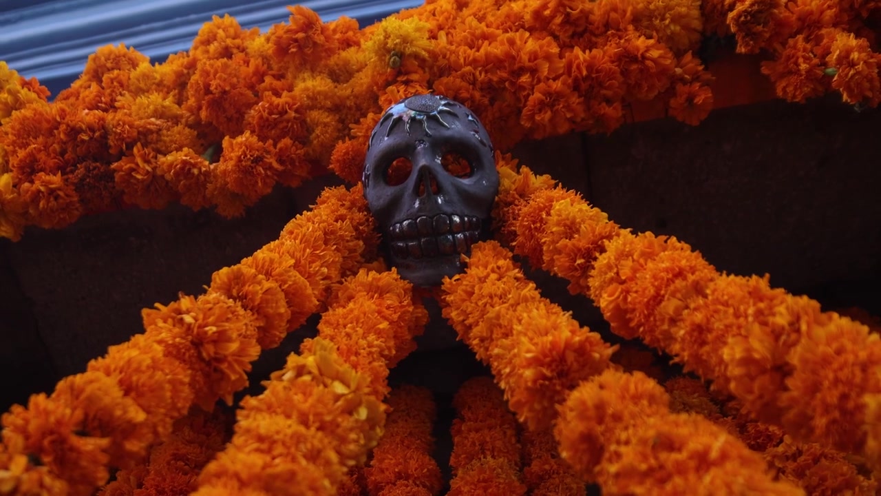 Decorazione con fiori arancioni e teschi per le strade di Oaxaca, Messico, durante la tradizionale parata annuale della cerimonia del Dia de los Muertos