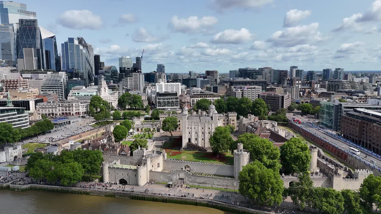Aerial pan of London’s iconic Tower of London with striking contrast of historic architecture and modern city skyscrapers in the backdrop.