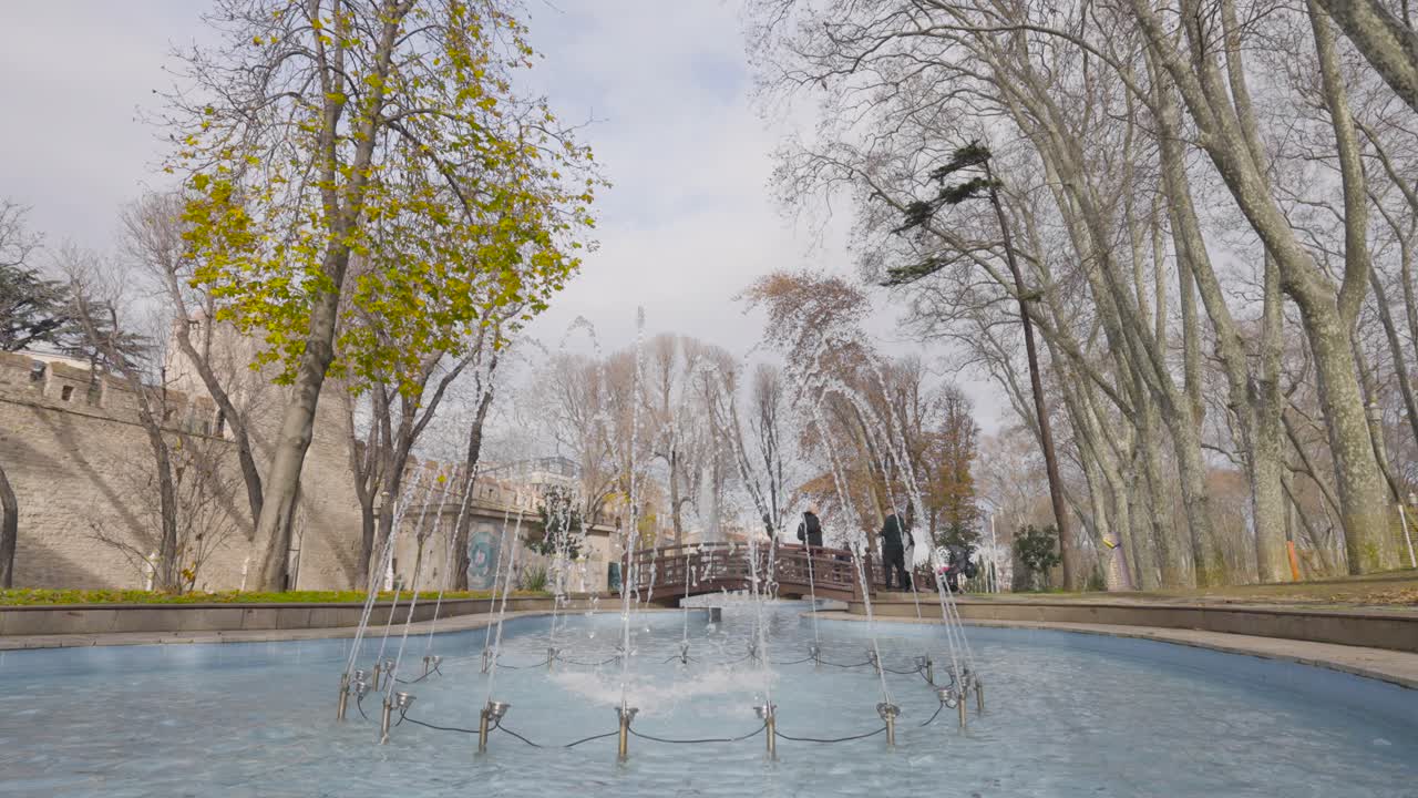 fuente del parque con árboles de otoño y personas