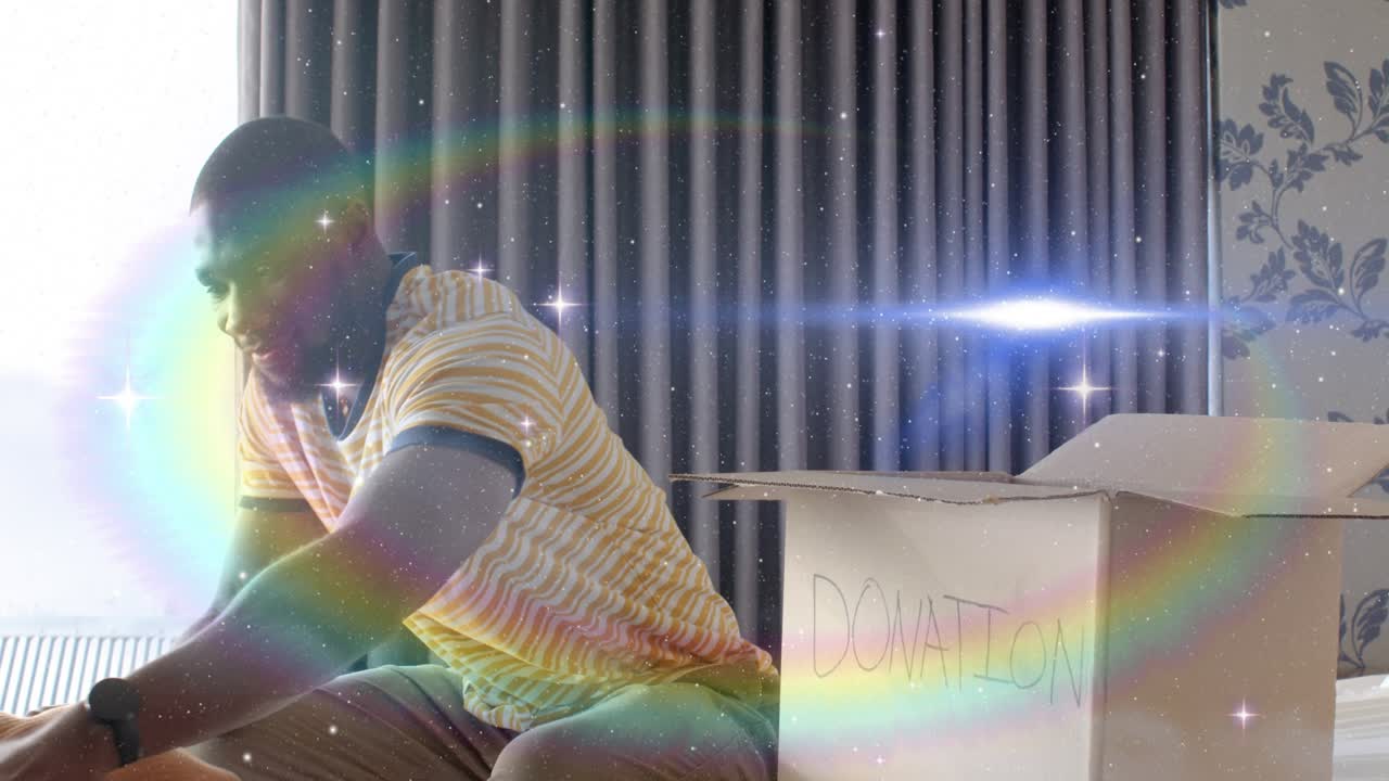 Man picking blue shirt, checking, folding, packing into donation box for charity; sparkles overlay