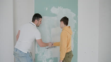 father and son repairing a wall