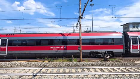 red high-speed train passing green train in milan